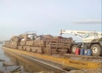 Barcaza fluvial cargando maquinaria